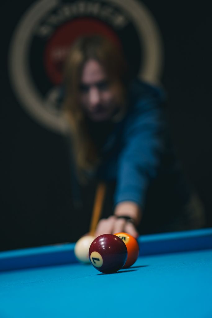 Billiards player aiming at pool table in Kyiv, Ukraine sports scene.